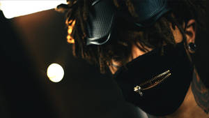 留著辮子的人，在昏暗燈光下戴著黑色面罩和網眼護目鏡。 — Scarlxrd 壁紙