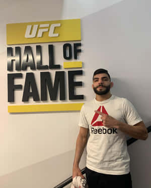 穿著Reebok襯衫的男人在室內指著UFC名人堂標誌。 — 終極格鬥冠軍賽 壁紙