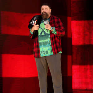 摔角手在紅色舞台上拿著麥克風和外套 — WWE GIF 壁紙