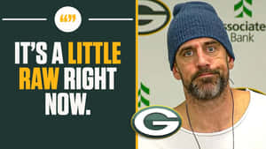 戴藍色毛帽、穿白襯衫的男人，在 Green Bay Packers 標誌旁邊，附有引文。 — 亞倫·羅傑斯 壁紙