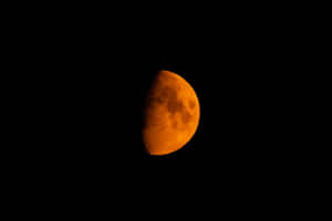 在黑暗夜空中發出橙色光芒的半月 — 美麗的夜晚 壁紙
