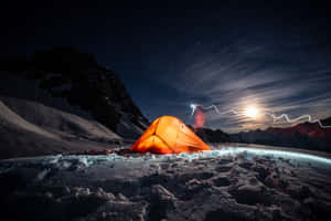 在白雪皚皚的山景中，一個橙色帳篷在星空下被閃電照亮。 — MacBook Air 壁紙