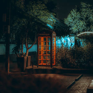 夜晚在城市環境中亮起的復古橙色電話亭。 — 霓虹燈 壁紙