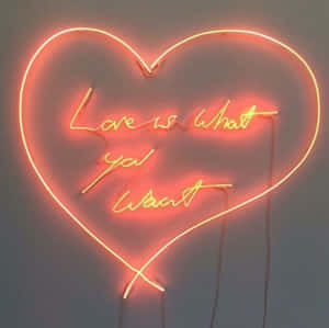 心形霓虹燈，上面有訊息 love is what you want 在牆上發光