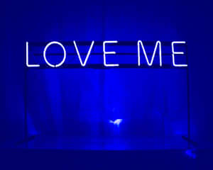 一個在深藍色房間裡發光的霓虹燈牌，上面寫著 LOVE ME。 — 藍色美學電腦 壁紙