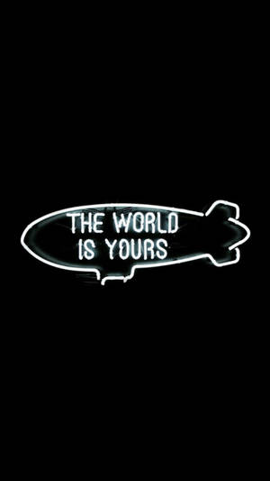 黑色背景上帶有「The World Is Yours」文字的飛船形霓虹燈牌。 — 世界是你的 壁紙