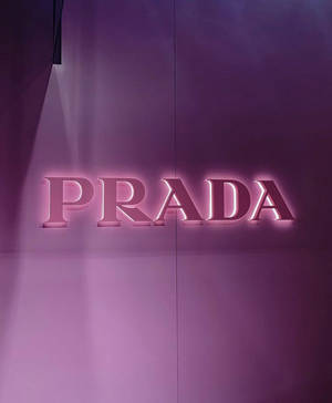 Prada標誌在紫色牆壁上以粉紅色照亮。 — Motorola Razr Ultra 2025 壁紙