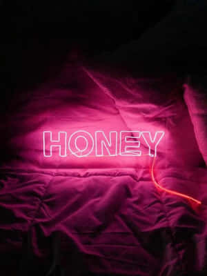 在昏暗房間的深色床罩上，一個寫著honey的粉紅色霓虹燈牌。 — 美學粉色GIF 壁紙