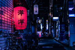 紅色燈籠照亮了一條狹窄的日本小巷，晚上有自行車停放在旁邊。 — 3:2 壁紙
