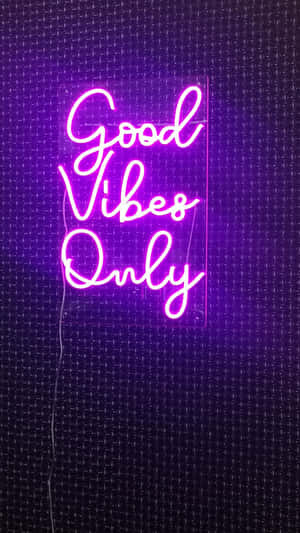 深色牆上的紫色霓虹燈牌寫著 Good Vibes Only。 — 霓虹紫 壁紙