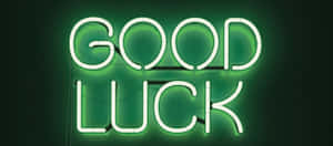一個明亮的綠色霓虹燈牌，在深色背景上寫著good luck。 — 好運 壁紙