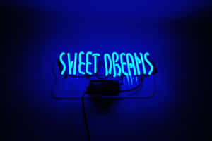 藍色霓虹燈牌在黑暗的牆壁上寫著 sweet dreams。 — 城市燈光 壁紙