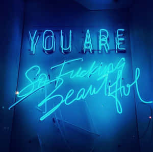 藍色霓虹燈牌，在深色牆壁上以粗體字顯示「YOU ARE So Fucking Beautiful」。 — 美學深藍 壁紙