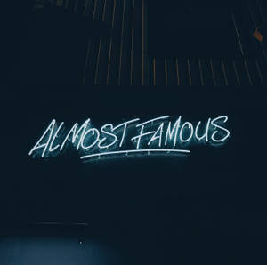霓虹燈牌寫著「Almost Famous」，在黑暗的牆壁上發出藍光。 — 名畫 壁紙