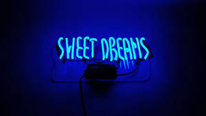 深色牆壁上寫著 sweet dreams 的藍色霓虹燈牌。 — 霓虹藍動畫 壁紙
