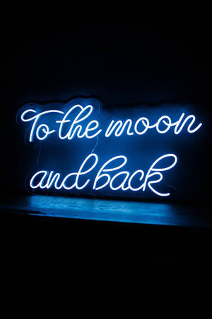 藍色霓虹燈牌，上面寫著 'To the moon and back'，掛在深色牆上。 — 霓虹藍動畫 壁紙
