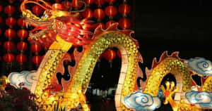 一個大型的發光龍燈籠，在夜晚被紅色燈籠包圍。 — 春節 壁紙