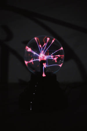 一個在黑暗房間中帶有電火花的發光電漿球。 — 燈泡 壁紙