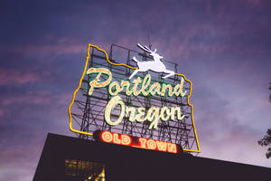 形狀像俄勒岡州的霓虹燈牌，有跳躍的鹿和Portland Oregon文字，在暮色中。