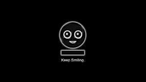 一個發光的黑色笑臉，有白色眼睛和嘴巴，下方有文字 Keep Smiling。 — 簡約暗黑美學 壁紙