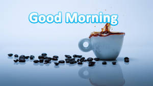 咖啡杯在藍色反光表面上散落咖啡豆，帶有「Good Morning」文字。 — 咖啡美學 壁紙