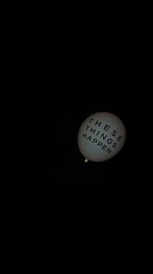 一個白色氣球，上面有「These Things Happen」字樣，漂浮在黑暗中。 — 氣球 壁紙