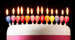 生日蛋糕上點燃了彩虹心形蠟燭，拼出 happy birthday。 — 生日祝福 壁紙