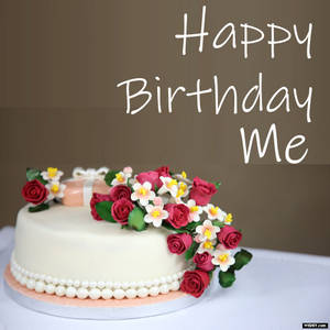 白色生日蛋糕，以紅玫瑰和白花裝飾，帶有 Happy Birthday Me 文字。