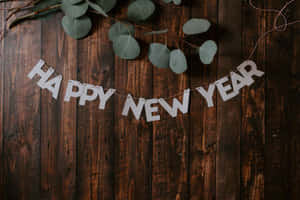 Happy New Year 橫幅搭配尤加利葉與木質背景 — 新年 壁紙