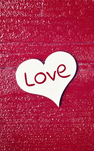 有紋理的紅色牆上，白色愛心帶有紅色 'Love' 文字和水滴。 — 愛情電話 壁紙