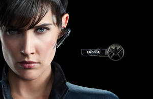 一個戴著S.H.I.E.L.D.耳機的認真女特工，背景是黑色。 — 人格面具 壁紙