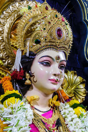 一尊裝飾過的印度教神像，戴著金色王冠和花環。 — Maa Durga 壁紙