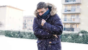 男人裹著冬季外套，勇敢面對積雪街道。 — 寒冷 壁紙