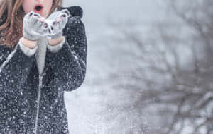冬天裡，孩子戴著貓耳手套和深色外套吹雪。 — 寒冷 壁紙