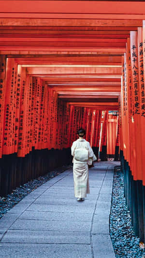 穿著白色和服的人穿過神社的紅色鳥居 — 手機 壁紙