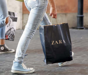 人在城市人行道上提著Zara購物袋行走 — Zara 壁紙