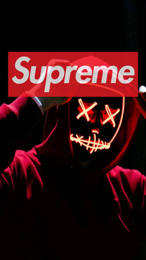 穿著紅色連帽衫的人戴著發光骷髏面具，手持Supreme標誌。 — 紅色至尊 壁紙