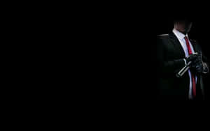 一個穿著西裝和紅色領帶的男人在黑暗中手持槍枝。 — 刺客教條 壁紙