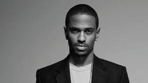一個穿著西裝和鏈條項鍊、表情嚴肅的男人在工作室肖像中。 — 史蒂芬·柯瑞 壁紙