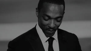 穿著西裝的男人在黑白中低頭微笑。 — 金·凱瑞 壁紙