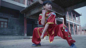 穿著紅色武術服的小孩在庭院練習姿勢 — 運動 壁紙
