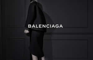一個穿著黑色Balenciaga服裝的人體模型在深色鑲板牆前。 — 巴黎世家 壁紙