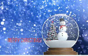 雪球內有雪人和樹，背景為藍色閃爍，帶有Merry Christmas文字。 — 簡約聖誕 壁紙