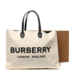 Burberry手提袋，配有黑色手柄和標誌，旁邊有棕色盒子。 — Burberry 壁紙