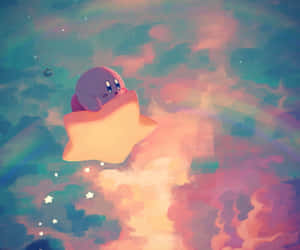粉紅色 Kirby 騎著發光星星穿過色彩繽紛的夢幻天空，有柔軟雲朵和星星。 — 卡比 壁紙