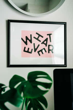 裱框粉紅色 'WHAT EVER' 藝術印刷品在龜背竹葉和圓鏡上方。 — 名言 壁紙