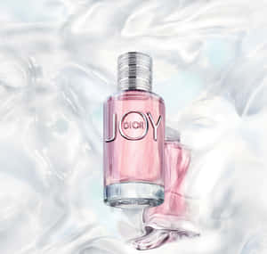 粉紅色Dior Joy香水瓶在閃爍的液體中，附近有另一個瓶子。 — Dior 動態 壁紙