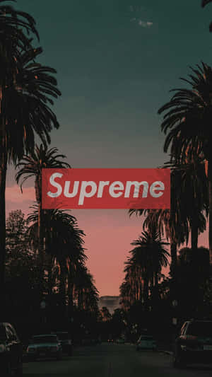 暮色中棕櫚樹成蔭的街道，天空中央有一個紅色Supreme標誌。 — 時尚感 壁紙