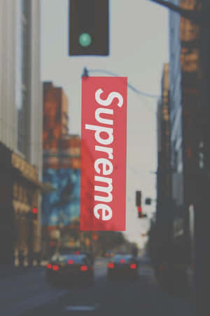 紅色Supreme標誌疊加在模糊的城市街道場景上。 — 酷炫iPhone 壁紙