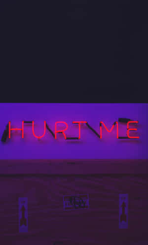 紅色霓虹燈牌寫著 hurt me，安裝在紫色牆壁上，下方是木地板。 — Realme Pad 2 壁紙